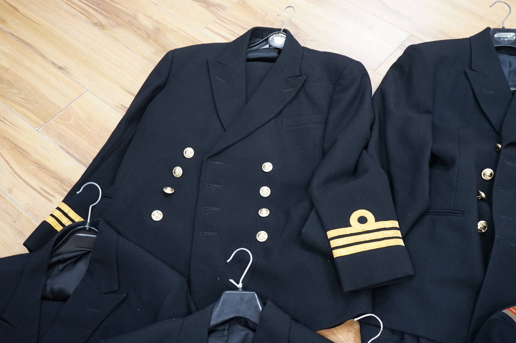 A Royal Navy officer's great coat, cap and four other Navy Officer's jackets. Condition - fair/good